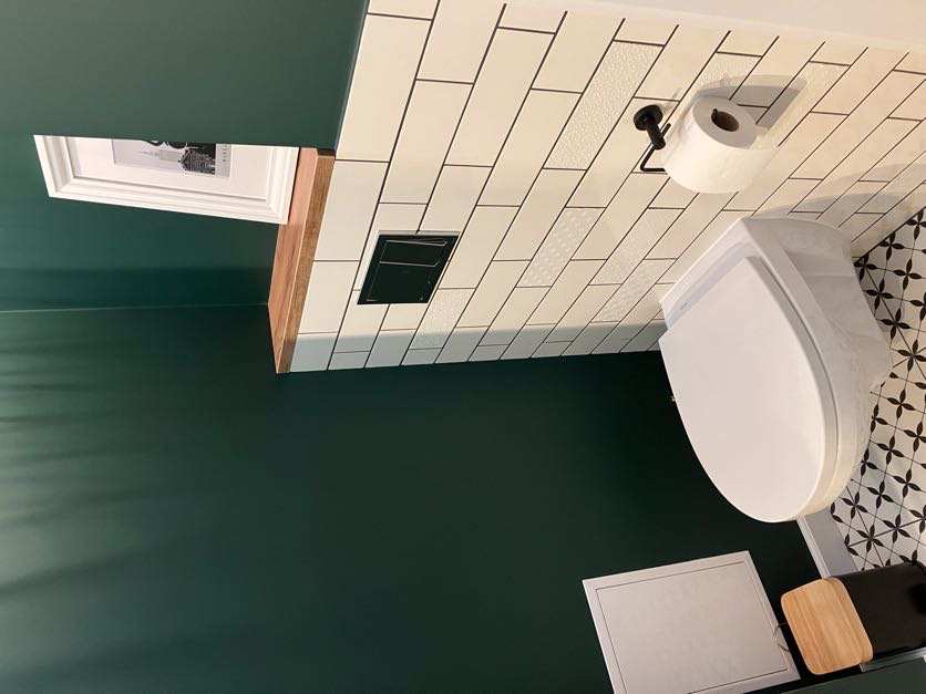 Umywalka z drewnianym blatem w zielonej łazience